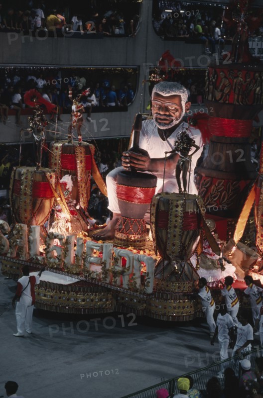 BRAZIL, Rio de Janeiro, Carnival float with large model of a man surrounded by dancers