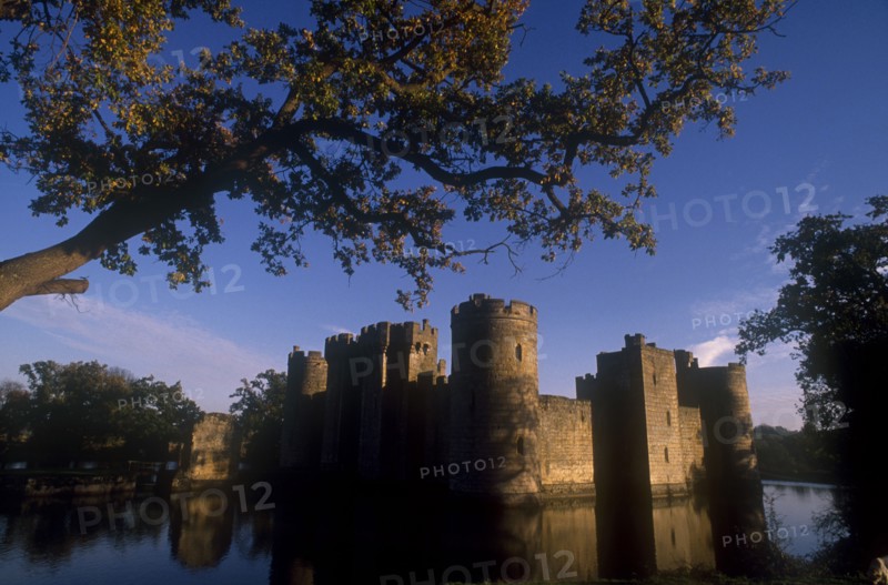 ENGLAND, East Sussex, Bodiam, The Castle and moat seen through trees