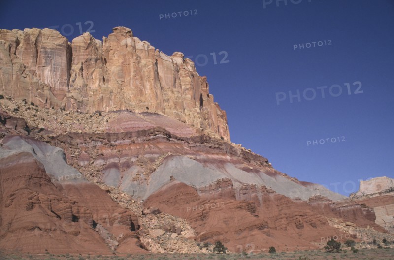 USA, Utah, Capitol Reef National Park. Towering ochre and white and red rock walls displaying sedimentary layers