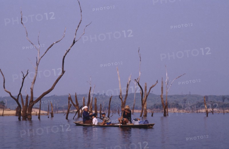 LAOS, Near Talat, Family in a canoe on a lake in a flooded valley