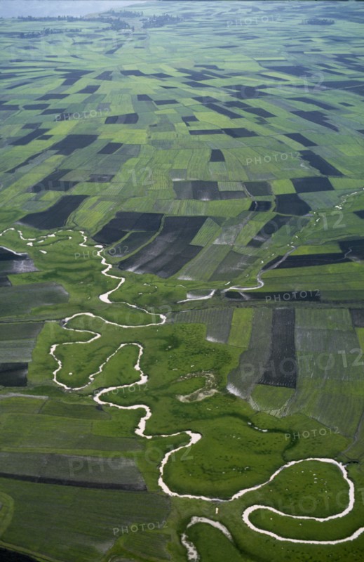 ETHIOPIA, South West, Landscape, Aerial view over river meandering through agricultural land.