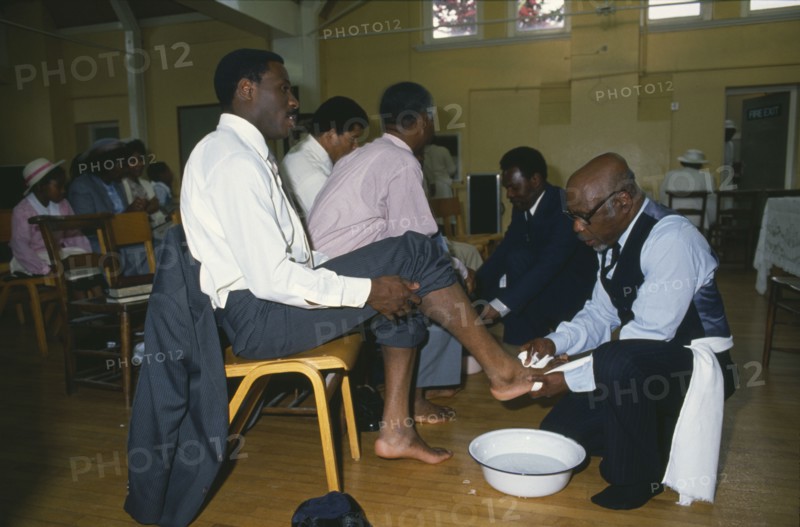 ENGLAND, London, Religion, Pentecostal church service.  Members of the congregation taking part in the washing of feet ceremony.