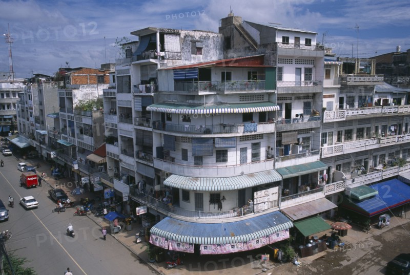CAMBODIA, Phnom Penh, "City view over converging streets, one well maintained and the other partly destroyed after the Khmer Rouge regime.  Both lined with shops with apartments above "