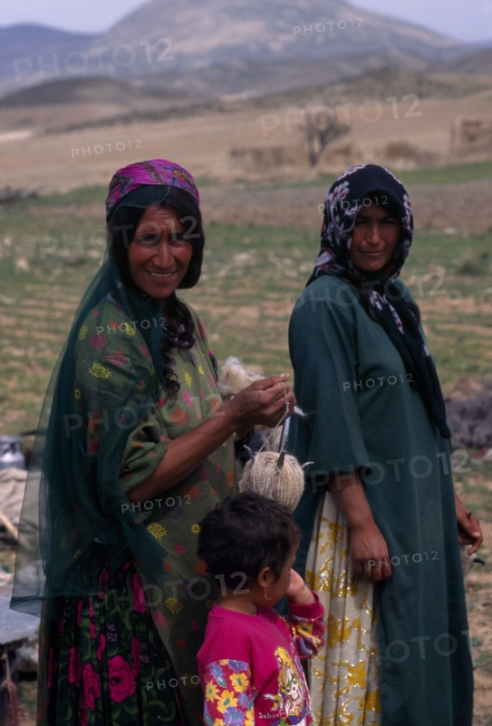 IRAN, Zagros Mountains, "Qashqai nomads on annual immigration through the Zagros Mountains.  Two women and child, three-quarter portrait."