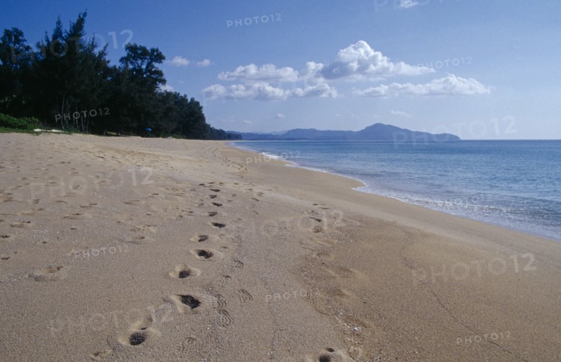 THAILAND, Phuket , Mai Khao Beach, View north west along empty sandy beach with lines of footprints in the foreground