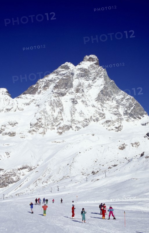 ITALY, Valle d’Aosta, Breuil Cervina, Skiers on slopes at the foot of the Matterhorn.