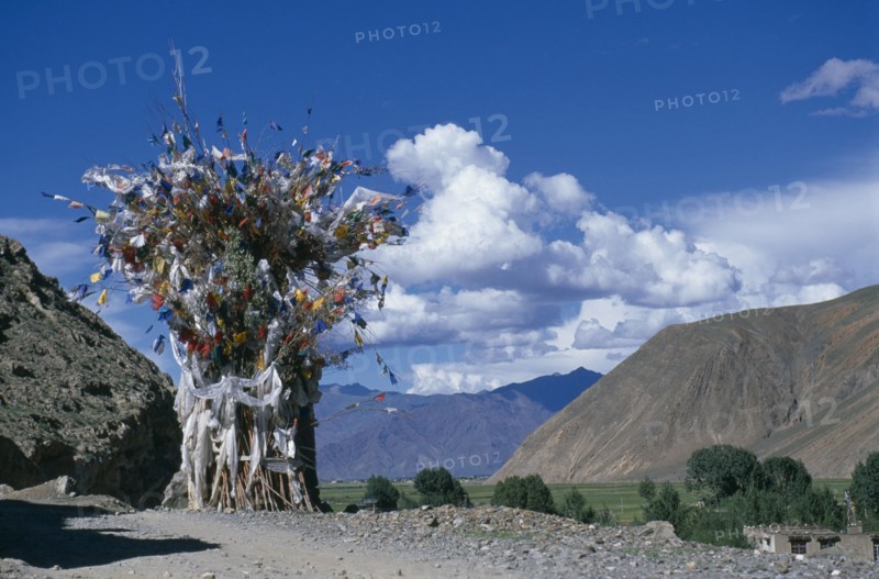 CHINA, Tibet, Shigatse, Prayer flags above a chorten on the roadside.