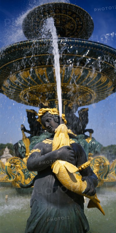 FRANCE, Ile de France, Paris, Place de La Concorde.  Detail of fountain with sculpted female figure holding a golden fish spouting water.