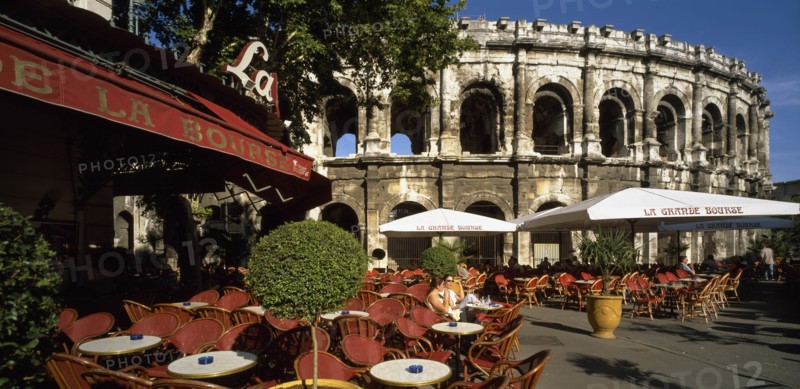 FRANCE, Languedoc-Roussillon, Gard, Nimes.  Cafe with outside tables in front of the Arenes.