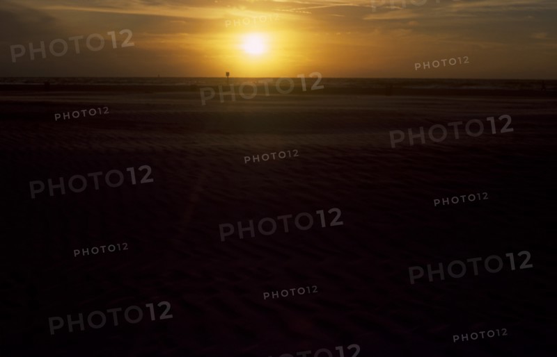 USA, Florida, Clearwater, Clearwater beach at sunset with bright orange sun over the sea.