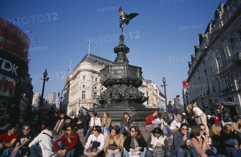 ENGLAND, London, Piccadilly Circus with mixed young crowd congregated around base of Alfred Gilberts statue of Eros