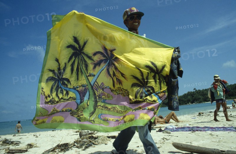 THAILAND, Koh Samui, Chaweng Beach , Sarong Vendor displaying colourful sarong on the beach