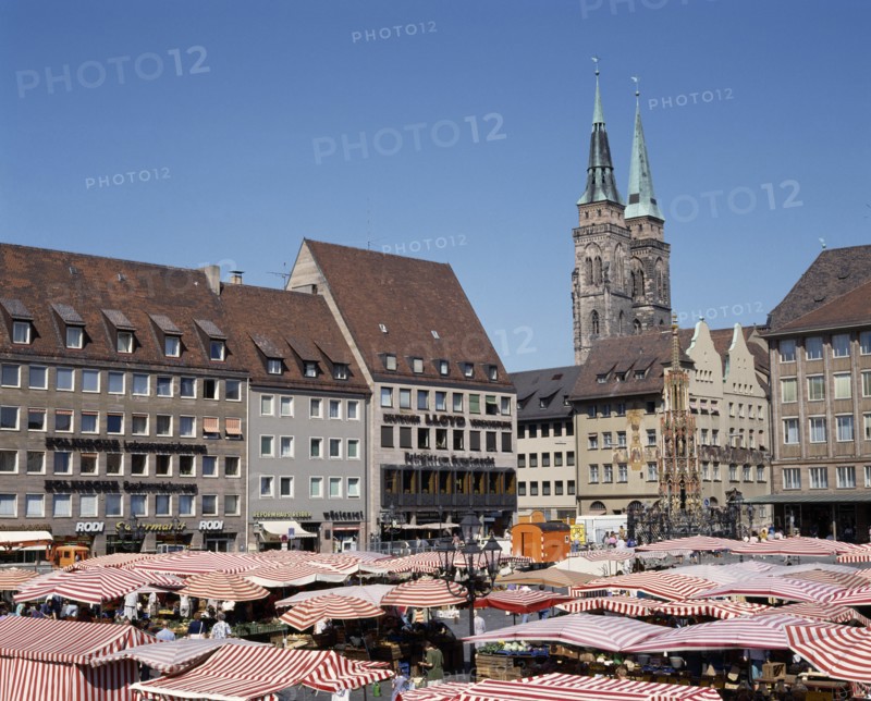 GERMANY, Bavaria, Nuremberg, The Hauptmarkt. Market stalls with red and white striped canopies in the square beneath the twin spired church
