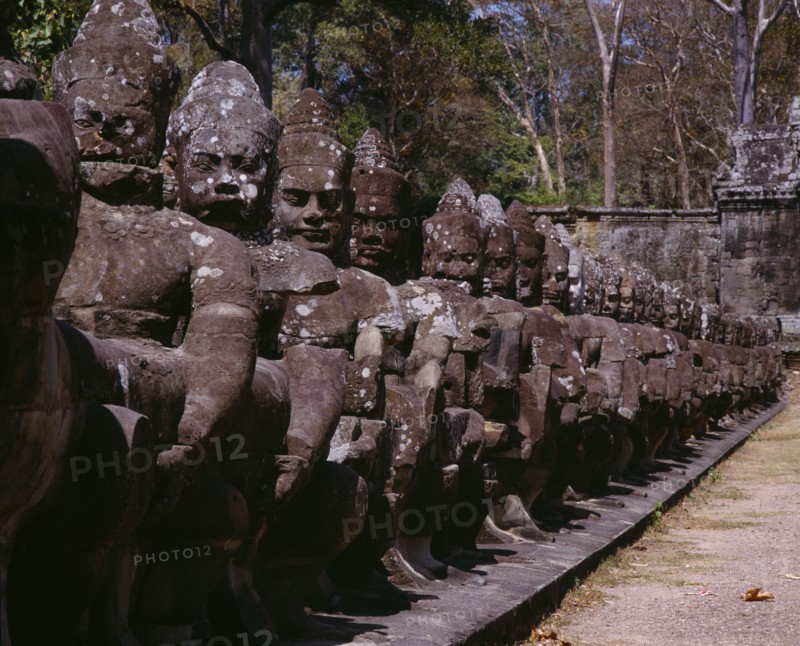 CAMBODIA, Angkor, Angkor Thom.  Close up of ancient stone figures lining causeway leading to gateways or gopuras.