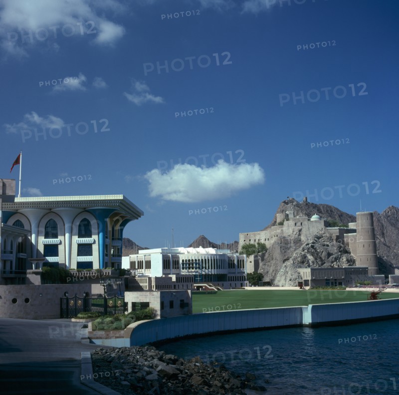 OMAN, Capital Area, Muscat, Al Alam Palace. Mosque in foreground with Fort Mirani behind