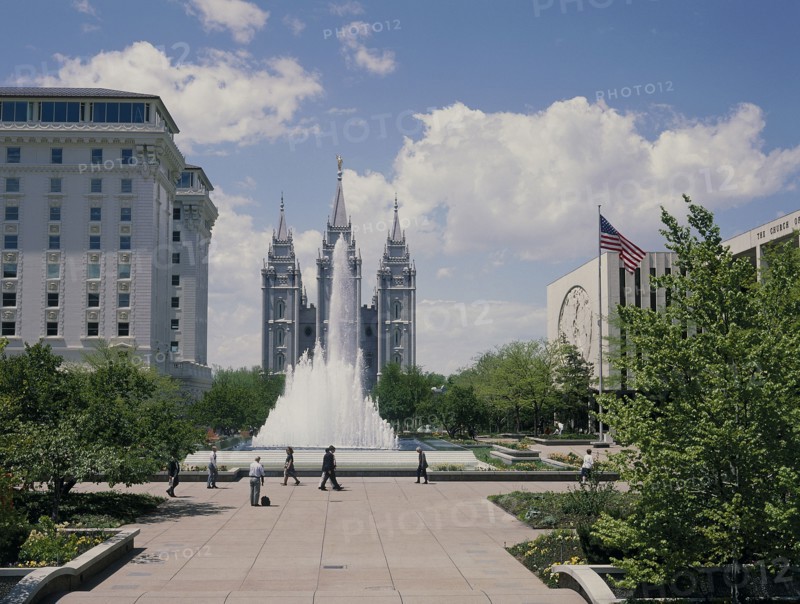 USA, Utah, Salt Lake City, The Mormon Temple beyond the fountain in the gardens with the US flag flying from a flagpole