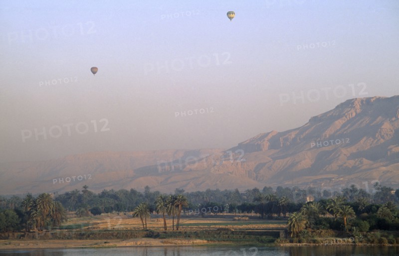 EGYPT, Upper Egypt, Luxor, Valley of the Kings with two hot air balloons over the river Nile at sunrise