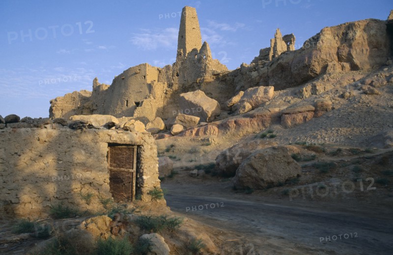 EGYPT, Western Desert, Siwa Oasis, Temple Of The Oracle 1 ruins on hillside above a road