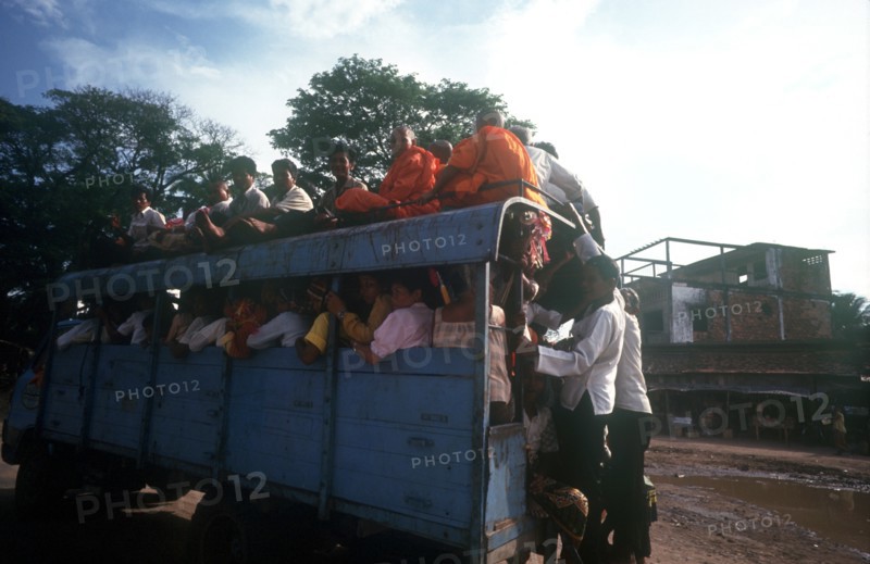 CAMBODIA, Kompong Chhnang, "Crowded public bus, passengers sitting on roof and holding on to back as well as packed inside."
