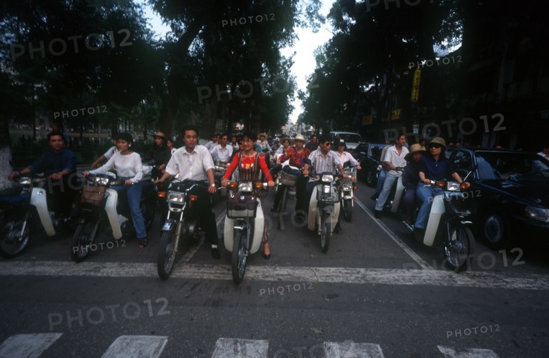VIETNAM, Hanoi, Rows of motorcyclists waiting to cross road.