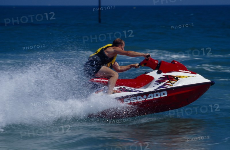 20002911 SPORT Watersports Jet Ski Man riding a jet ski on the sea at Littlehampton in West Sussex  England.  Viewed from the side.