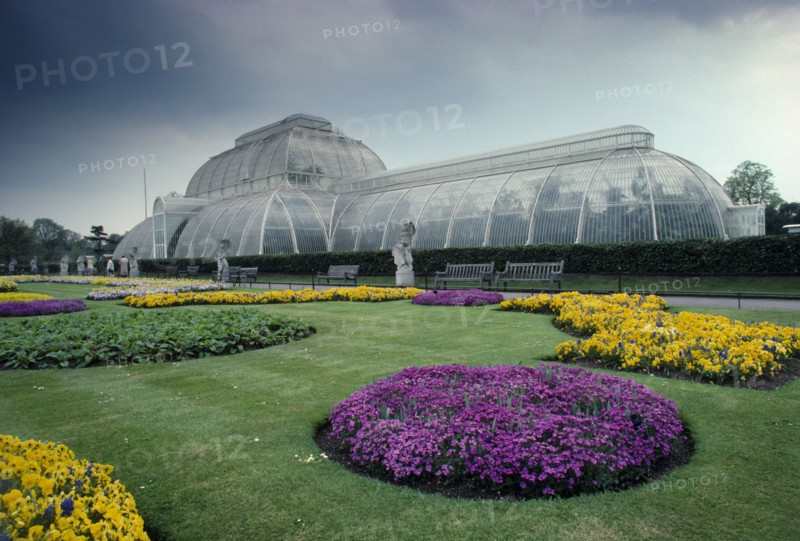 ENGLAND, London, Kew Gardens hot house with flower beds in the foreground.