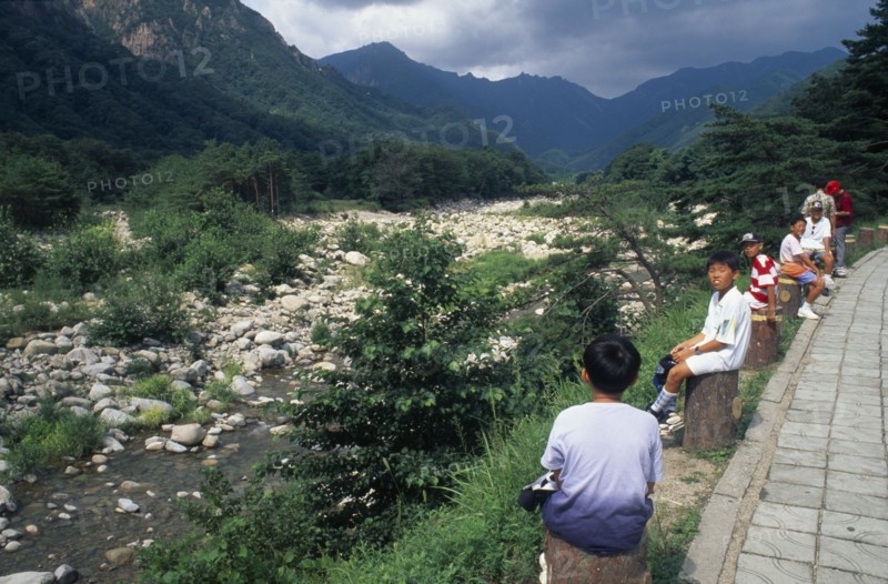 SOUTH KOREA, Soraksan Nat. Park, Sorak Mountains, Ssang-Chon River.  Children sitting beside almost dry river bed