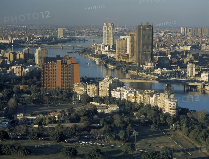 EGYPT, Cairo Area, Cairo, Elevated view looking Northwest over the Nile with tall city buildings and parks with trees