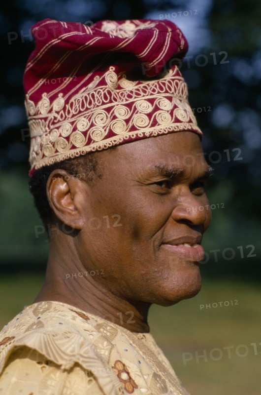 NIGERIA, Portraits, Men, Yoruba chief.  Portrait wearing hat and robe.