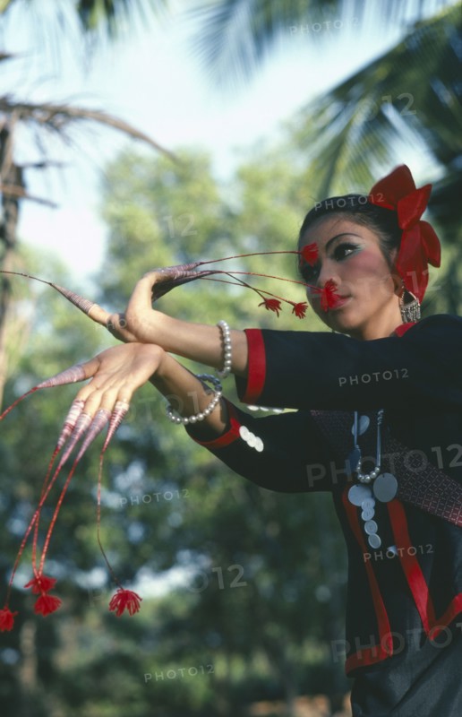 THAILAND, North East, Dancer of Phu Thai tribe with long stalked flowers on her fingers