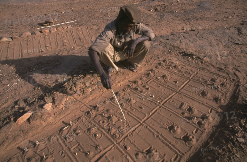MALI, Pays Dogon, Bongo, A Dogon sand diviner indicating fox paw prints for telling fortunes.