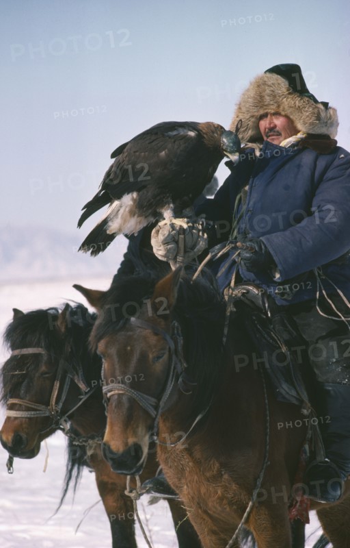 CHINA, Xinjiang Province, Kazakhs, Kazakh man on horseback with eagle used for hunting