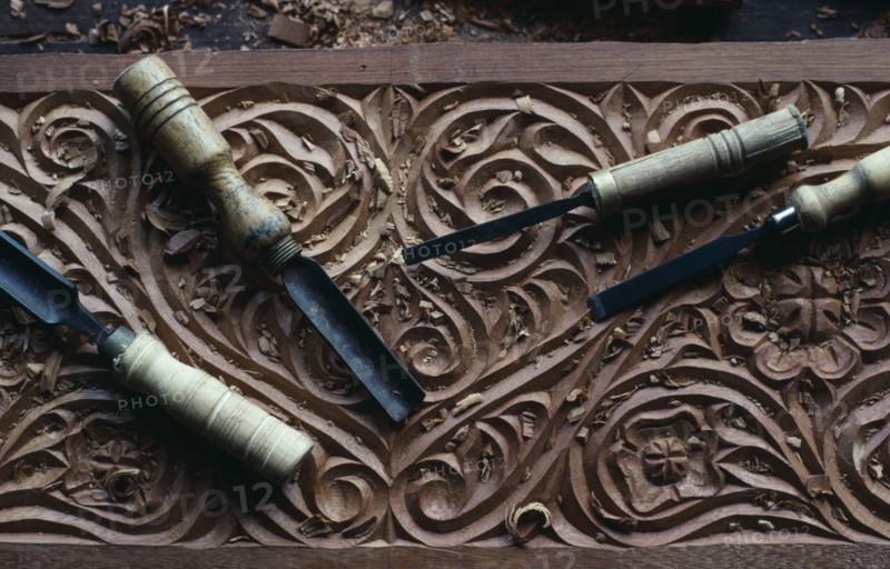 KENYA, Lamu Island, Traditional Swahili culture wood carving detail with tools lying on top
