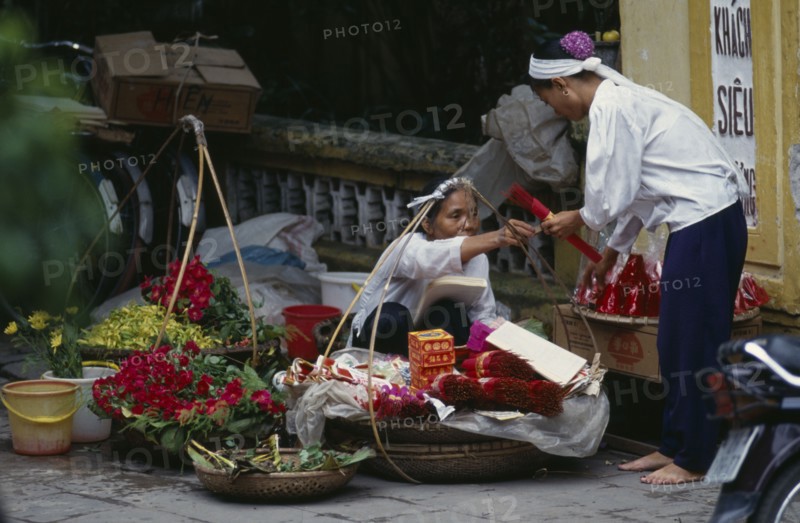 VIETNAM, North, Hanoi, Woman selling religious offerings from the pavement outside a temple