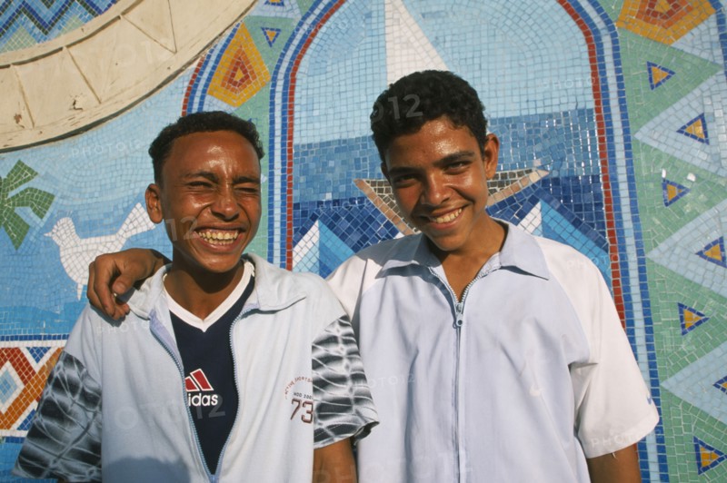 EGYPT, Nile Valley, Aswan, "Two smiling boys, one with arm resting across shoulders of other. "
