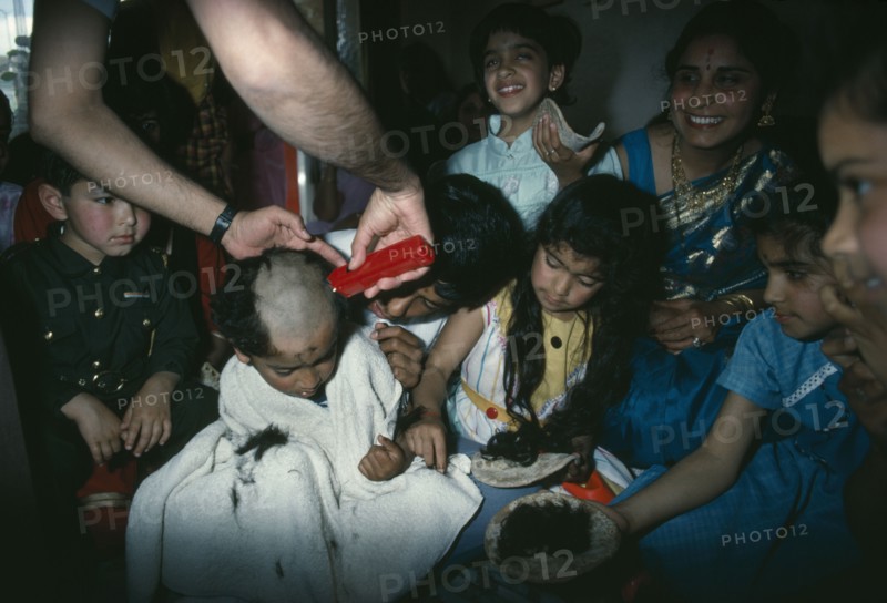 RELIGION, Hindu, Hindu family participating in head shaving of young son.