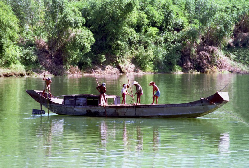 VIETNAM, Central, Hue, Fishermen on boat spearing for shell fish