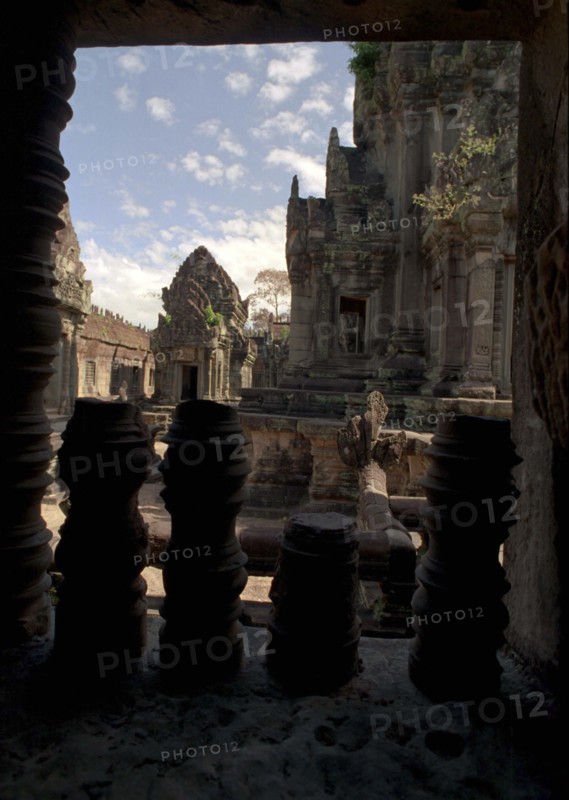 CAMBODIA, Angkor, View through archway over pink sandstone ruins of Banteay Srei or The Citadel of the Women