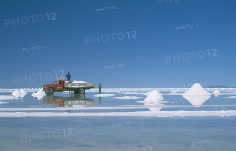 BOLIVIA, Uyuni, Salar de Uyuni, View over the white salt flats with salt piled up ready for collection by truck