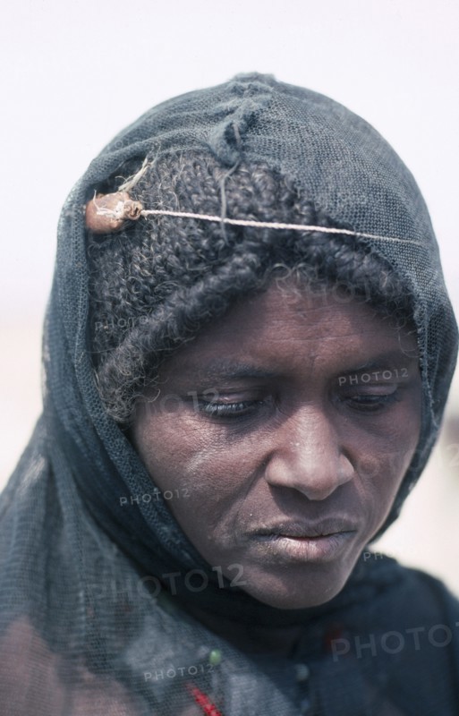 ETHIOPIA, Danakil Depression, Portrait of Afar woman with verses of the Koran tied around her head to cure migraine.