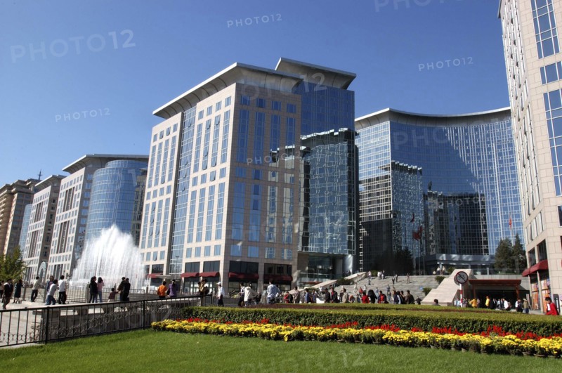 CHINA, Beijing, Modern city architecture with red and yellow flowerbeds in the foreground