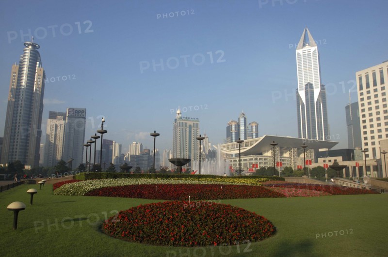 CHINA, Shanghai, Modern city skyline seen from gardens with formal flowerbeds in the foreground