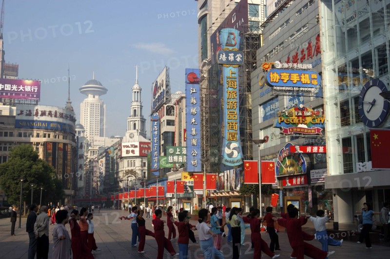 CHINA, Shanghai, Nanjing Road walking street. Commercial shopping street with group of people exercising outside