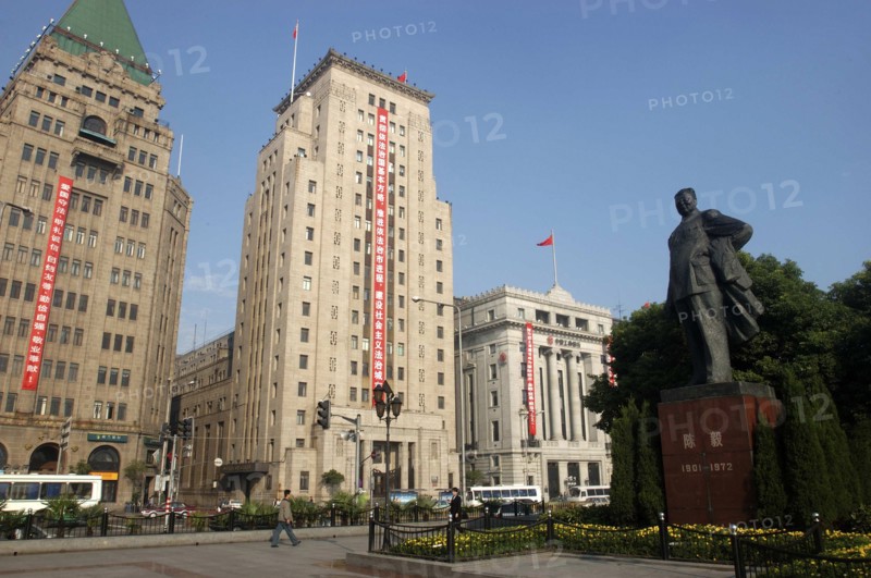 CHINA, Shanghai, The Bund aka Zhong Shan Road. 1930s style waterfront architecture including the Peace Hotel and the Bank of China with statue of Mao in the foreground