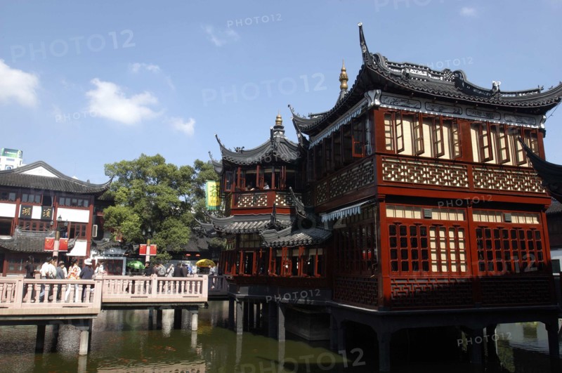 CHINA, Shanghai, Yuyuan Gardens. Bridge leading to traditional style architecture built on stilts over water
