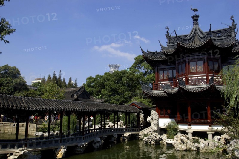 CHINA, Shanghai, Yuyuan Gardens. Covered bridge leading toward traditional style architecture built over water