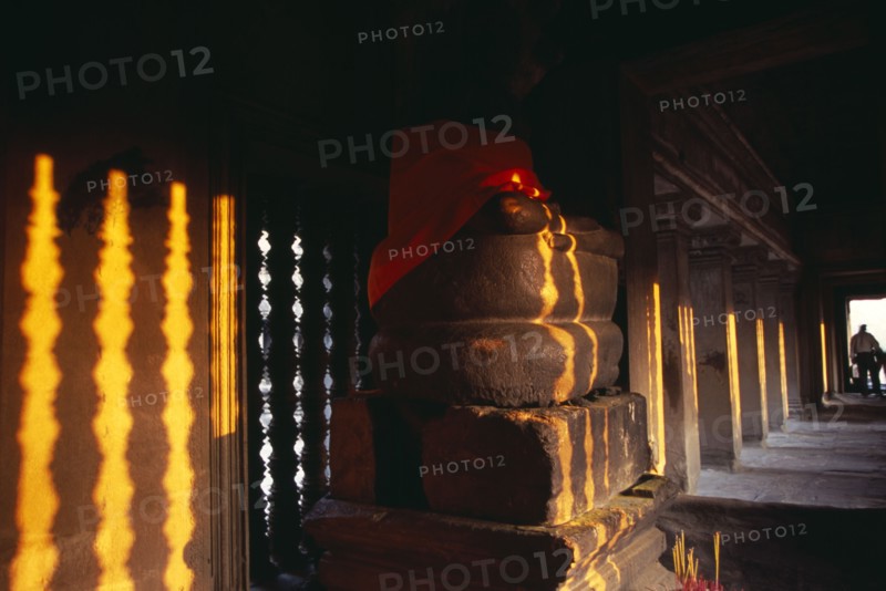 CAMBODIA, Siem Reap, Angkor Wat, Buddha statue in gallery on the third level at sunset