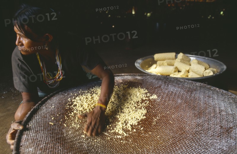 COLOMBIA, Amazonas, Santa Isabel, Macuna woman sieving manioc that has previously been grated washed and pressed.