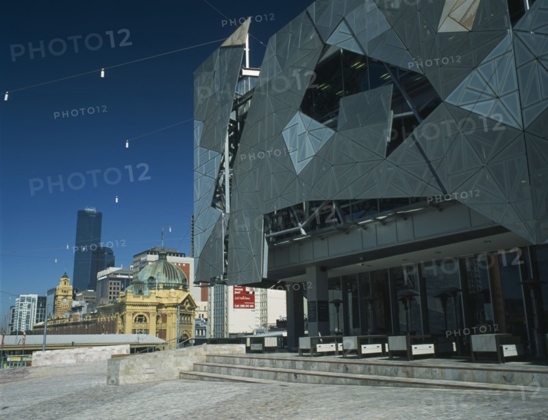 AUSTRALIA, Victoria, Melbourne, Federation Square modern facades with the Flinders Street railway station and Rialto Tower beyond