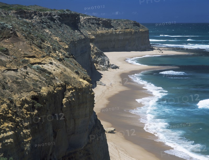 AUSTRALIA, Victoria, Near Port Campbell, Great Ocean Road. View along rugged rocky cliffs and sandy beach